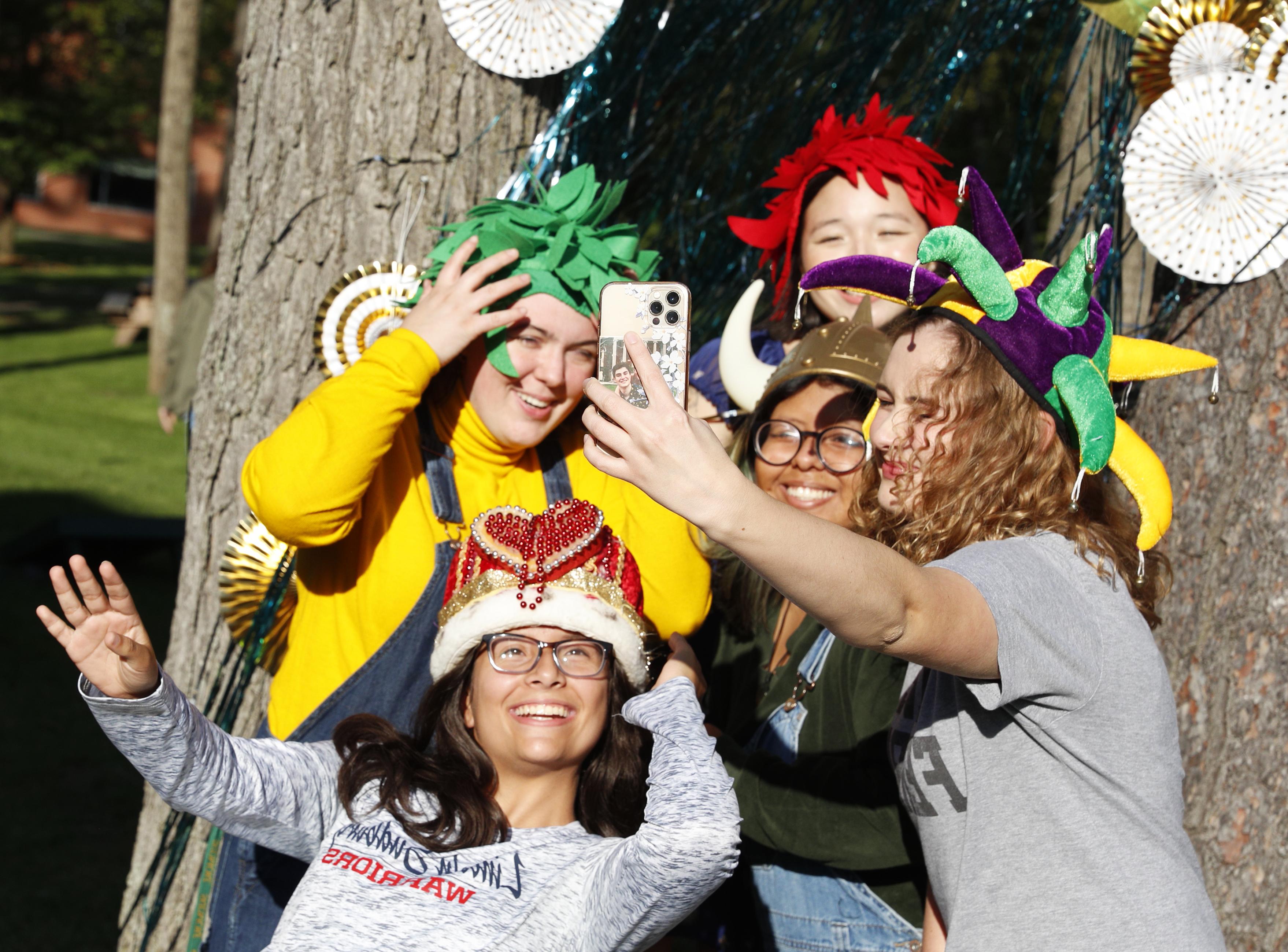 student take a selfie while wearing costume hats